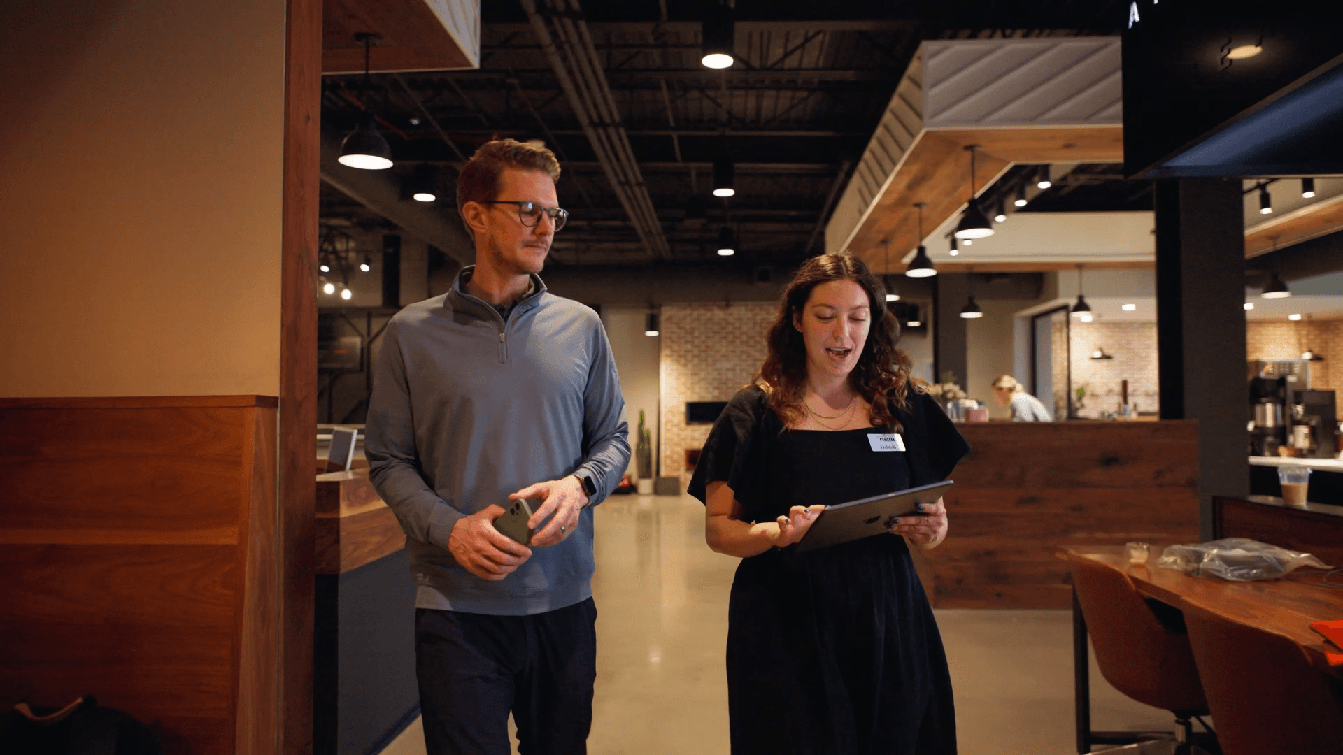 Roam employees walking with an iPad checking event information on Basewell